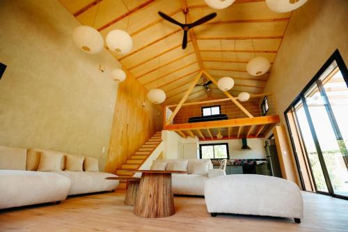 a living room with white furniture and a wooden ceiling at Le Chalet de la Boussonie in Les Vans