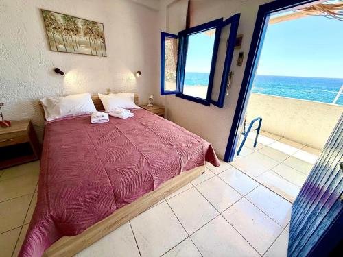 a bedroom with a bed and a view of the ocean at Blue Thea in Lentas