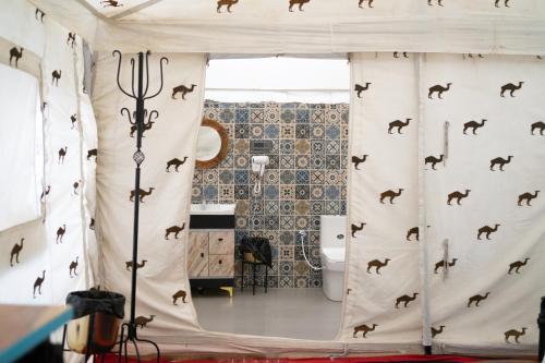 a bathroom with a shower curtain with horses on it at Camp The Sanga Manali in Tāndi