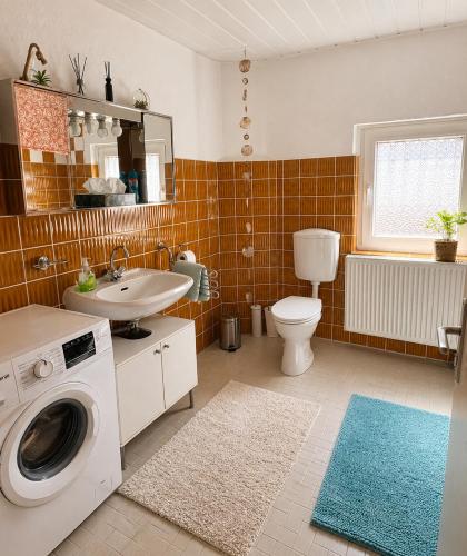 a bathroom with a toilet sink and a washing machine at Apartment Hope Inn in Groß-Zimmern