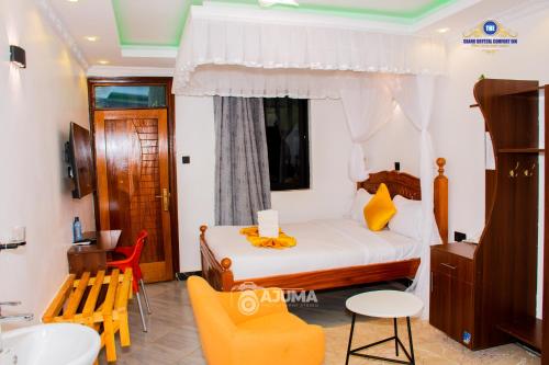 a bedroom with a bed and a bathroom with a sink at The Grand Brystal Hotel in Busia