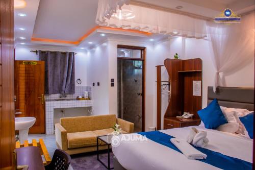 a bedroom with a large bed and a bathroom at The Grand Brystal Hotel in Busia