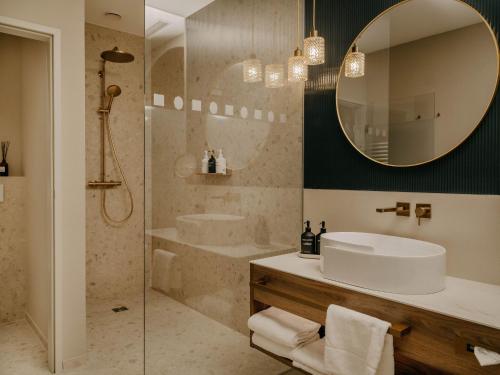a bathroom with a sink and a shower with a mirror at IMLAUER Palais Mirabell in Salzburg