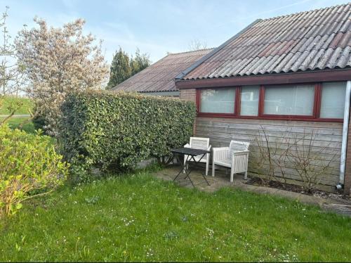 a house with a table and two chairs in the yard at Seasons in Warmenhuizen