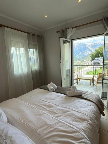 a bedroom with a large bed with a large window at Panorama House in Pramanta