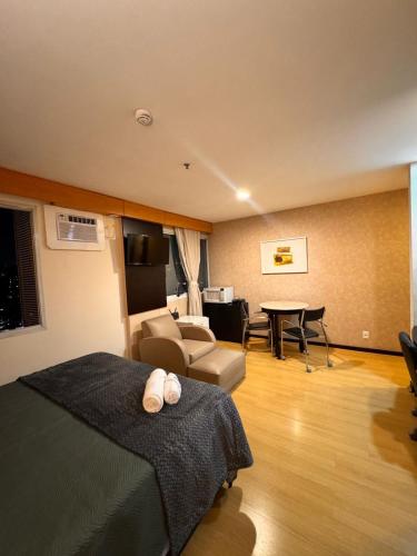 a hotel room with a bed and a living room at Flat Vila Olimpia Hotel Experience in São Paulo