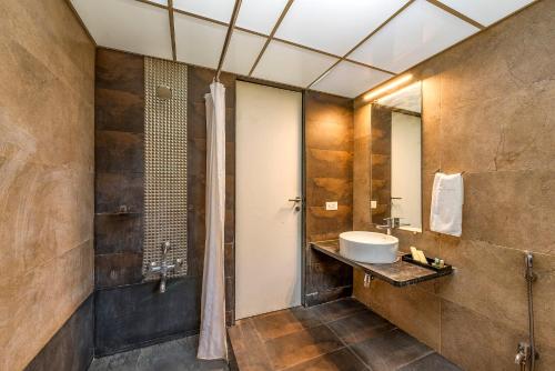 a bathroom with a sink and a shower at Palmwoods Retreat in Pune