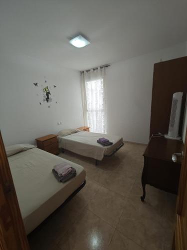 a room with two beds and a desk and a television at Altet San Francisco in El Alted