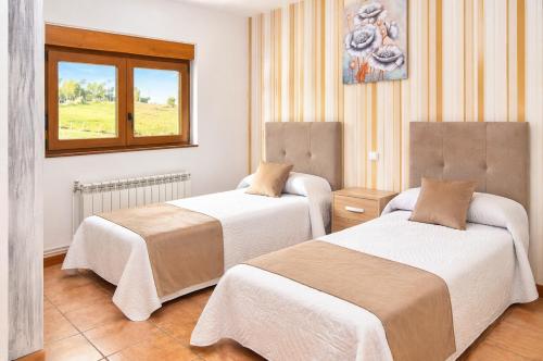 a hotel room with two beds and a window at El Carloto Lanchares in Lanchares