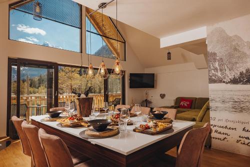 a dining room with a long table with chairs at JASNA NATUR Resort by the lake in Kranjska Gora
