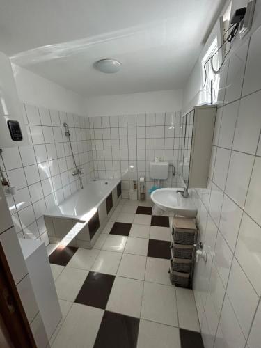 a white bathroom with a tub and a sink at Tóparti Camping in Tiszafüred