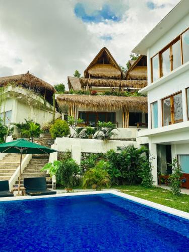 a swimming pool in front of a house at Garden Hill Views in Kuta Lombok