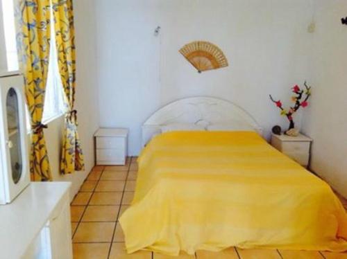 a bedroom with a yellow bed in a room at Ven OCEAN VIEW in Grand-Baie