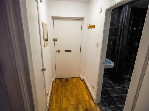 a hallway with a white door and a bathroom at Stylish Edinburgh Studio in Edinburgh