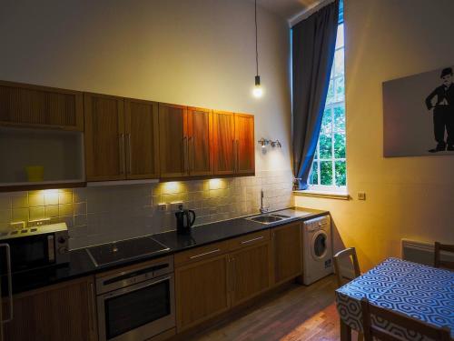 a kitchen with wooden cabinets and a sink and a window at Stylish Edinburgh Studio in Edinburgh