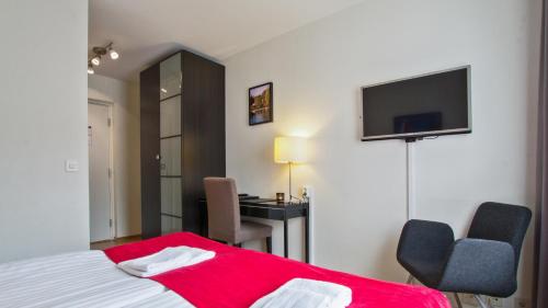 a bedroom with a bed and a desk and a television at Best Western Hotel City Gavle in Gävle