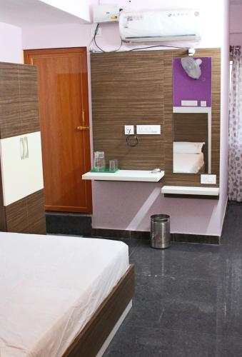 a bedroom with a bed and a wall with shelves at Sapphire Inn in Bangalore