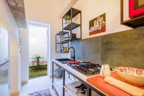 a kitchen with a stove and a counter top at GuestHost - Arkè Colorful Apartment in Giuggianello
