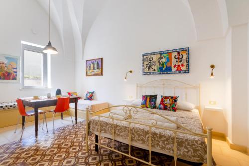 a bedroom with a bed and a table and a desk at GuestHost - Arkè Colorful Apartment in Giuggianello