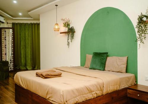 a bedroom with a large bed with a green wall at Temple Tree Homes in Bangalore