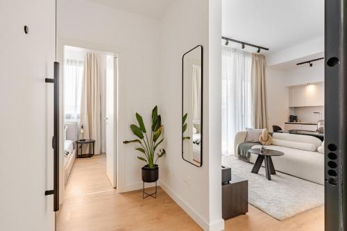 a white living room with a couch and a mirror at Yamas Urban Living Sequoia Residence in Limassol