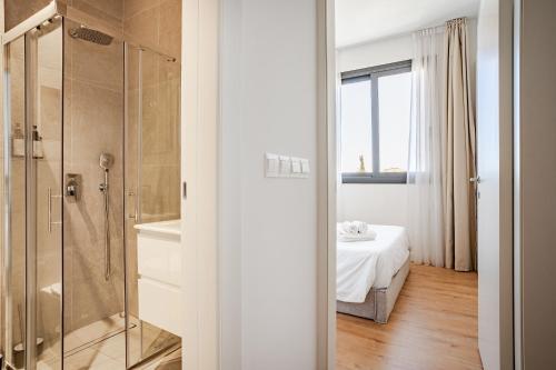 a bathroom with a shower and a bed in a room at Yamas Urban Living Sequoia Residence in Limassol