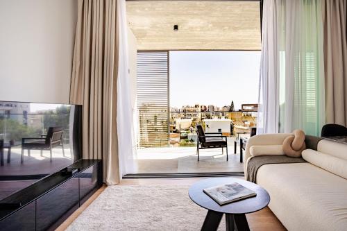 a living room with a couch and a flat screen tv at Yamas Urban Living Sequoia Residence in Limassol