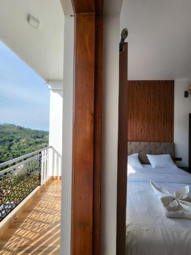 a bedroom with a bed and a balcony at The heights holidays in Kodaikānāl