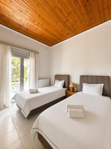 a bedroom with two beds and a wooden ceiling at Mata's Spacious Apartment in Astros