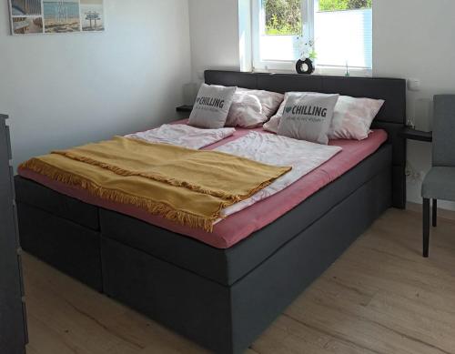 a bed with a black frame and pink sheets and pillows at Casa Lieselotte in Velden am Wörthersee