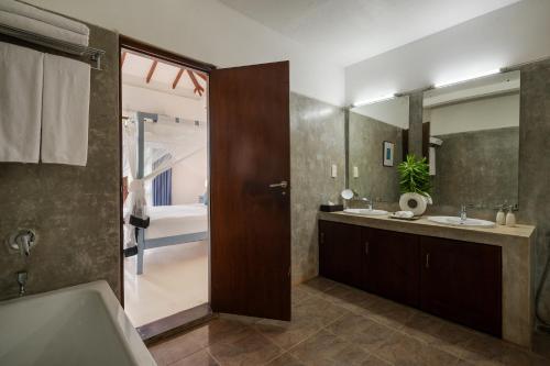 a bathroom with two sinks and a tub and a shower at Ranna Beach House in Ranna