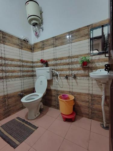 a bathroom with a toilet and a sink at Pinewood Sunrise Homestay Kasauli by Splendid Retreat Hotels in Kasauli