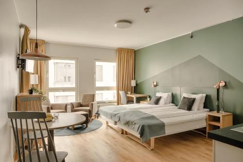 ein Schlafzimmer mit einem Bett, einem Tisch und Stühlen in der Unterkunft The Nooq Lund - Hotel & Studios in Lund