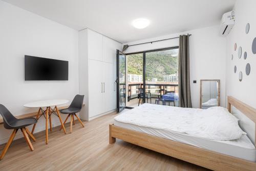 a bedroom with a bed and a table and chairs at Casa Al Mare Premium Residences in Rafailovici