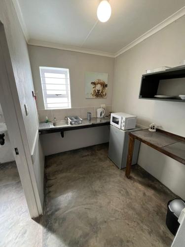 a small kitchen with a sink and a refrigerator at Windpomp Guesthouse in Beaufort West