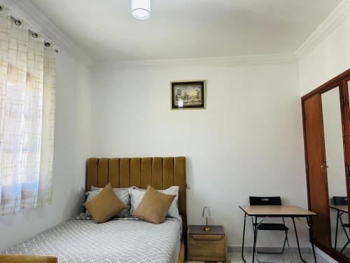 a bedroom with a bed and a laptop on a table at Cocon alpin -studio bien équipé in Ifrane