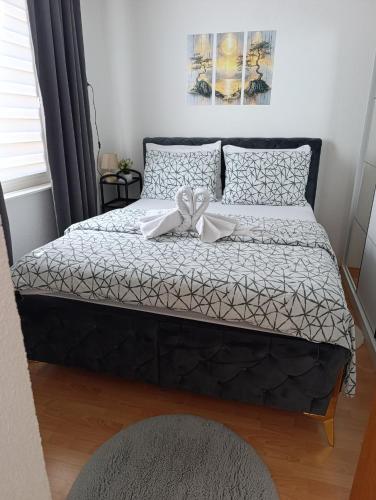 a bed with two white bows on top of it at Apartman City in Jajce
