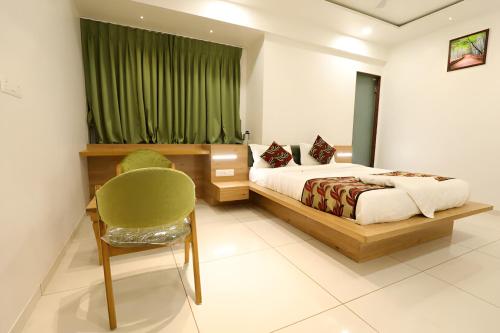 a bedroom with a bed and a green curtain at Nova Yashraj Hotel in Rajkot