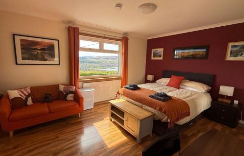 a bedroom with a bed and a couch and a window at Skeabost View in Tole