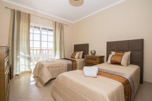 a hotel room with two beds and a window at Villa Florencio by Algarve Holidays in Estói