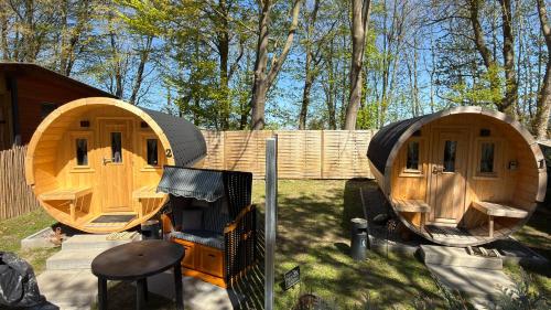 two small wooden houses sitting in the grass at Schlaffass am Sund in Altefähr