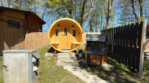 a wooden boat in a yard next to a fence at Schlaffass am Sund in Altefähr