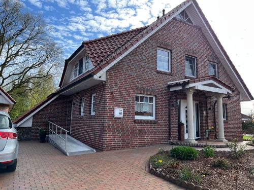 a brick house with a car parked in front of it at Ferienwohnung "Am Wichtelweg", 95176 in Rhauderfehn
