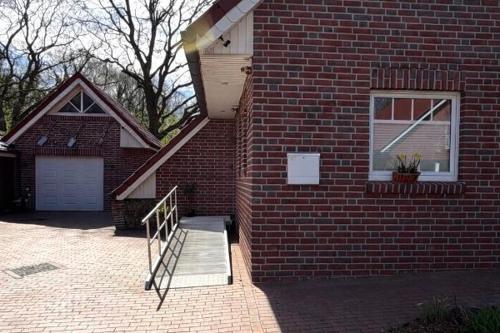 a brick house with a door and a stairway at Ferienwohnung "Am Wichtelweg", 95176 in Rhauderfehn