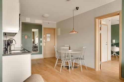 eine Küche und ein Wohnzimmer mit Tisch und Stühlen in der Unterkunft The Nooq Lund - Hotel & Studios in Lund