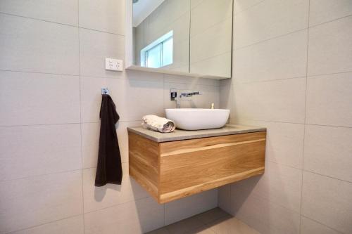 a bathroom with a sink and a mirror at White House Bendigo Garden Retreat in Epsom