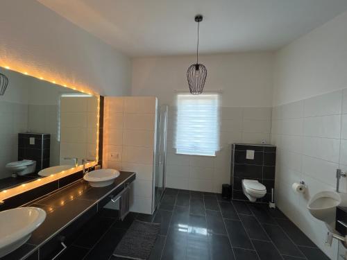 a bathroom with three sinks and two toilets at Ferienwohnung Monteurwohnung in Wadern