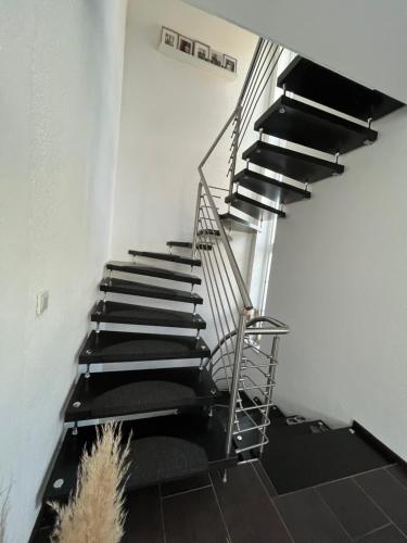 a spiral staircase in a white room with black mats at Ferienwohnung Monteurwohnung in Wadern