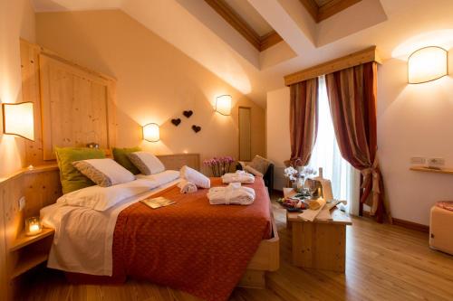a bedroom with a large bed with towels on it at Garden Relais in Borso del Grappa