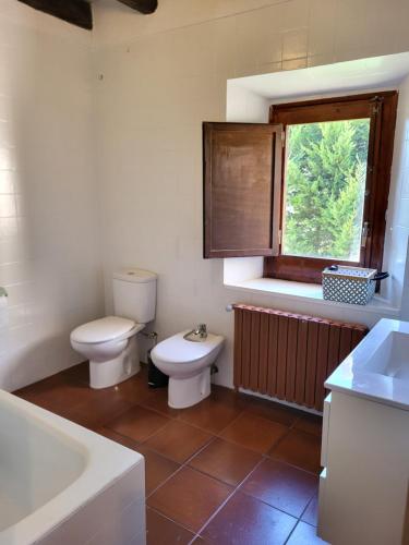 a bathroom with a toilet and a sink and a tub at Can Cuti in Santa Eulalia de Ríuprimer